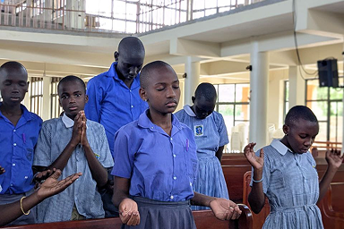 Primary students worshipping God during a school fellowship, organised by Junior.