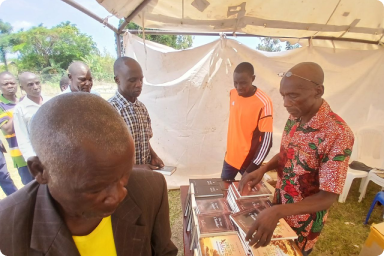 Dan distributing books and Bibles during a conference in Tororo district.