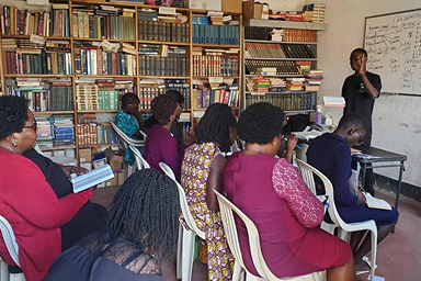A volunteer student at a Makerere Bible class guiding fellow ministers through a passage of Scripture.